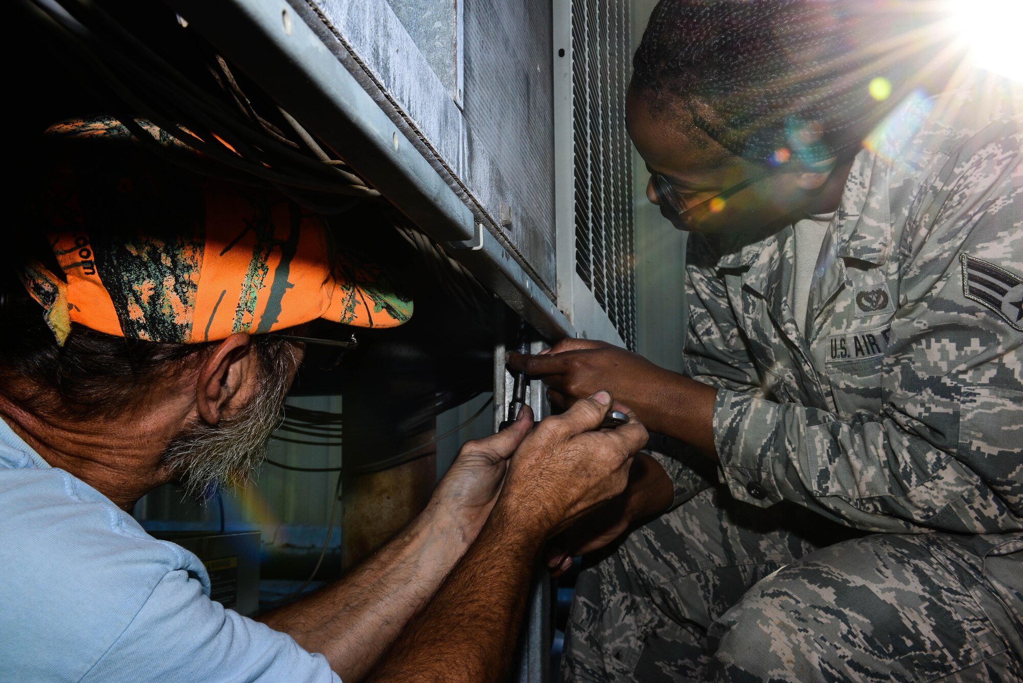 Jimmy Beattie, 2nd Civil Engineer Squadron HVAC civilian, and Senior Airman Brittany Parks, 2nd CES heating ventilation and air condition technician, remove protective grating so that a compressor can be replaced on an HVAC unit at Barksdale Air Force Base, La., Aug 23, 2016. HVAC Airmen maintain HVAC on the entire base to ensure Airman and civilians have a place to cool off from the hazardous climate of Louisiana. (U.S. Air Force photo/Senior Airman Luke Hill)