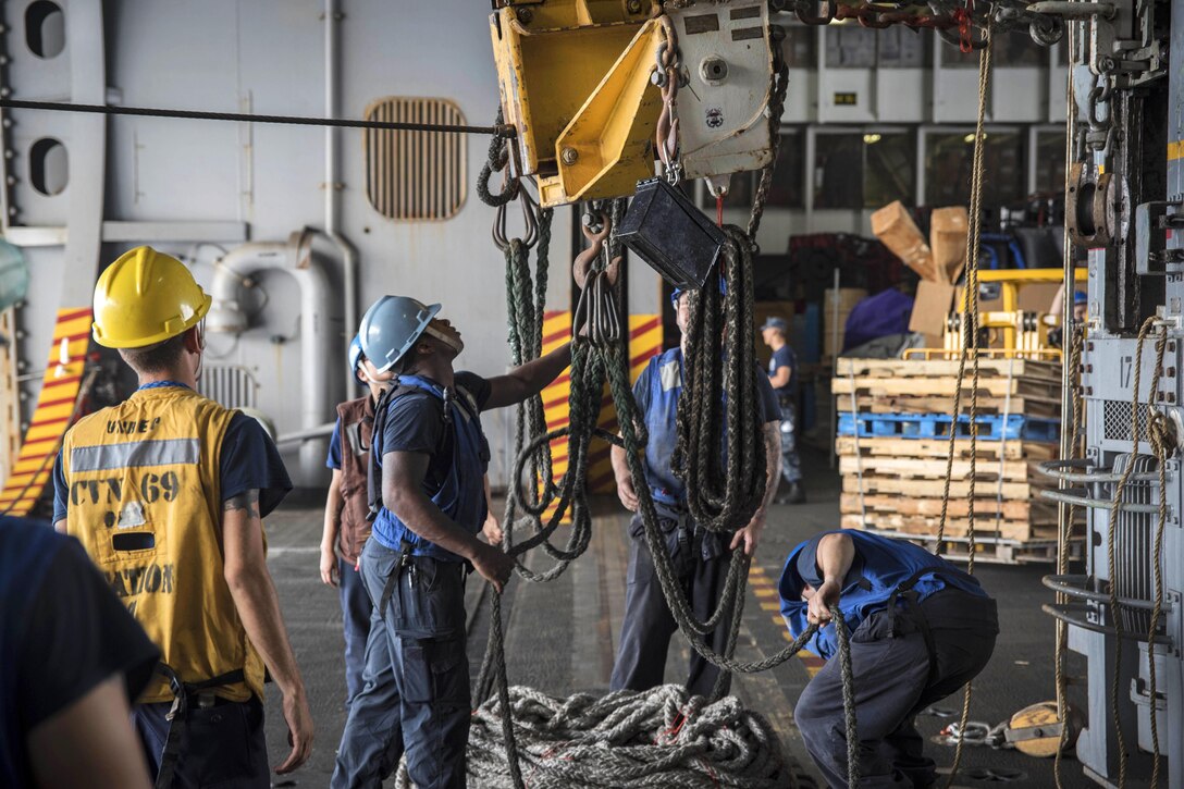 Sailors prepare to return a messenger line from the hangar bay of the aircraft carrier USS Dwight D. Eisenhower to the fast combat support ship USNS Arctic during a replenishment-at-sea in the Persian Gulf, Aug. 19, 2016. Navy photo by Seaman Apprentice Joshua Murray