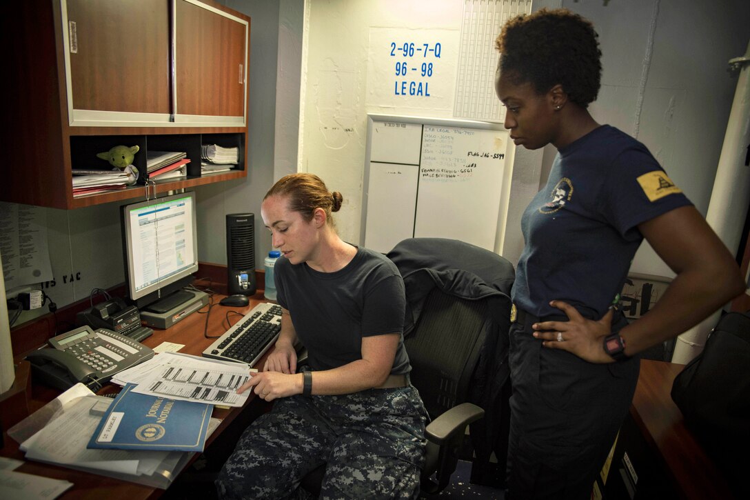 Navy Lt. Cynthia Parmley, left, reviews client intake forms with Navy Petty Office 1st Class Chardae Longshore in the legal office of the aircraft carrier USS Dwight D. Eisenhower in the Persian Gulf, Aug. 19, 2016. Navy photo by Seaman Apprentice Joshua Murray 