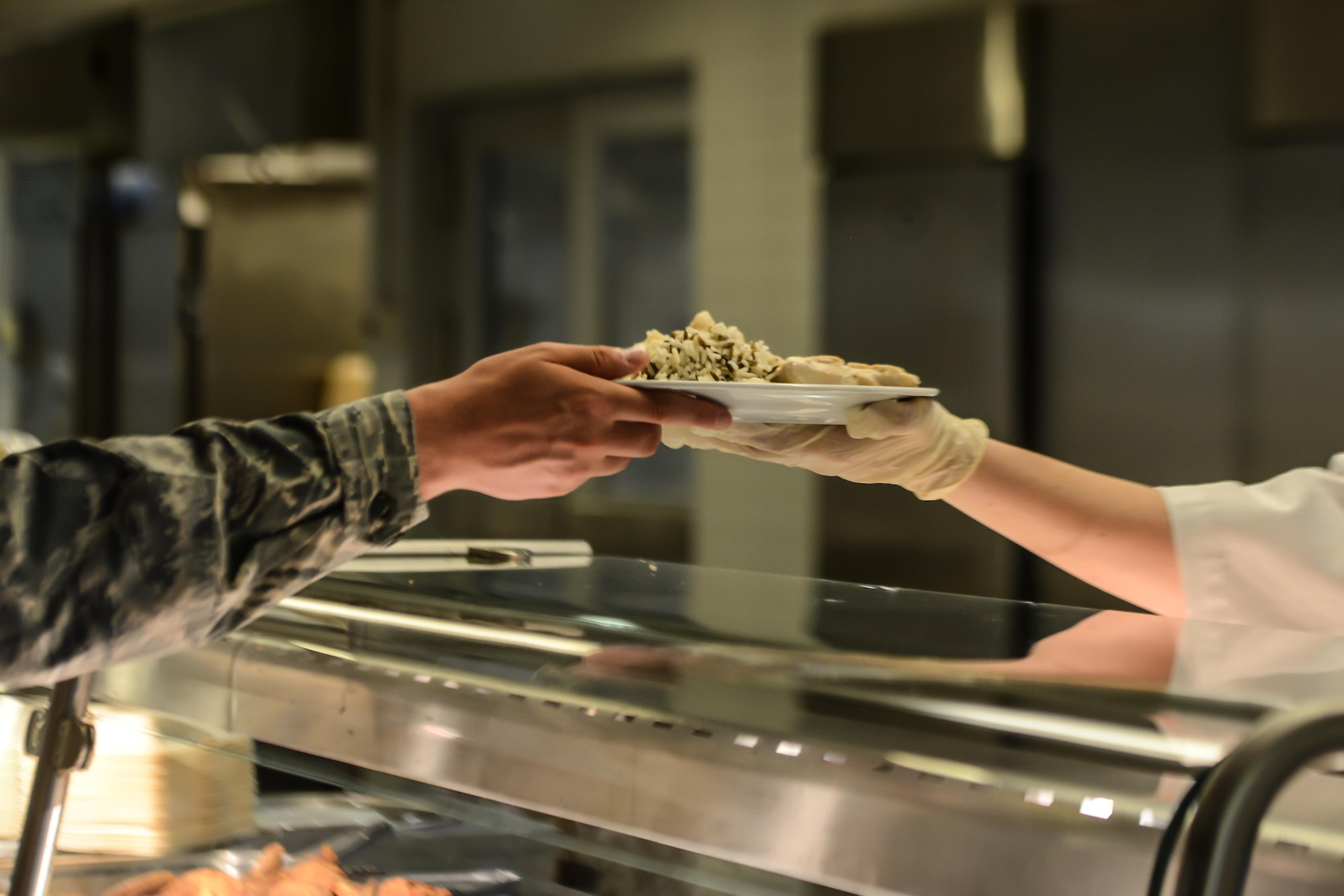 A food services Airman serves a customer at the Rheinland Inn Dining Facility, Aug. 29, 2016, Ramstein Air Base, Germany. The Rheinland Inn offers a wide variety of snacks, entrees, dessert and beverages. (U.S. Air Force photo/ Airman 1st Class Joshua Magbanua)