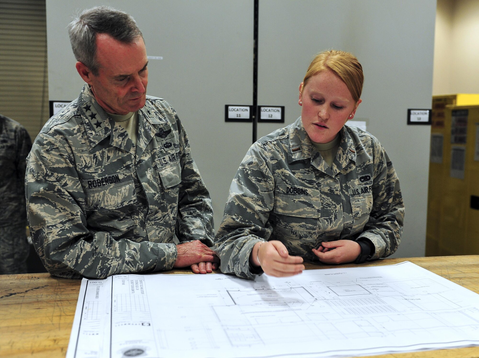 Lt. Gen. Darryl Roberson, commander of Air Education and Training Command, looks over proposed design changes to the 314th Aircraft Maintenance bay with 2nd Lt. Carissa Dobbins, 314th AMXS Sortie Support Flight commander, Aug. 22, 2016, at Little Rock Air Force Base, Ark. Dobbins explained that the expansion would improve storage for equipment and tools as well as provide more room for the maintenance teams to prepare for the day.  (U.S. Air Force photo by Staff Sgt. Jeremy McGuffin)