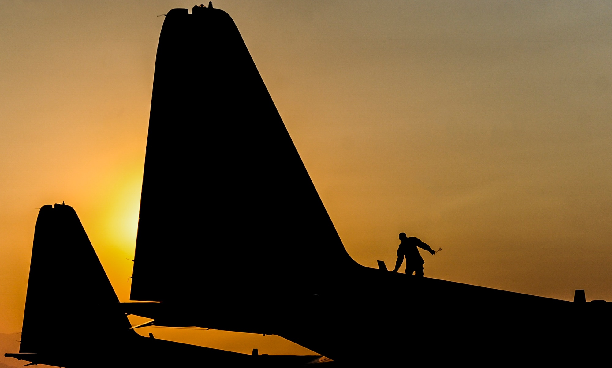 An Airman assigned to the 71st Rescue Squadron, Moody Air Force Base, Georgia, walks on top of an HC-130J Combat King II before Red Flag 16-4 night operations at Nellis Air Force Base, Nev., Aug. 25, 2016. Red Flag provides an opportunity for aircrew and military aircraft the ability to enhance their tactical operational skills alongside military aircraft from coalition forces. (U.S. Air Force photo by Airman 1st Class Kevin Tanenbaum/Released)