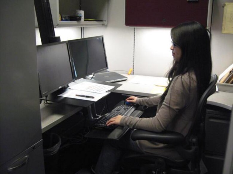 Karen Macatangay, industrial hygienist for the U.S. Army Corps of Engineers Sacramento District, demonstrates the correct seating position at a properly-fitted ergonomic work station.