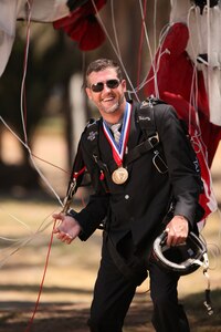 NSWC Corona engineer Taylor Cole poses wearing his parachute rig and championship medals.  