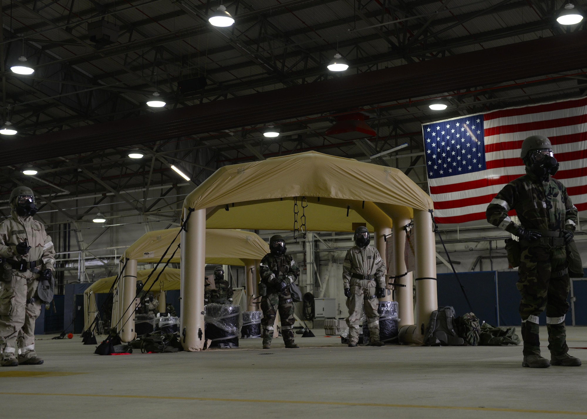 U.S. Air Forces in Europe aircrew flight equipment technicians set up decontamination stations in Hangar 7 as part of a USAFE AFE Chemical Defense Mobility Exercise at Royal Air Force Lakenheath, England, Aug. 25. AFE personnel practiced decontaminating aircrews exposed to simulated chemical, biological, radiological or nuclear contaminates. (U.S. Air Force photo/ Airman 1st Class Abby L. Finkel) 