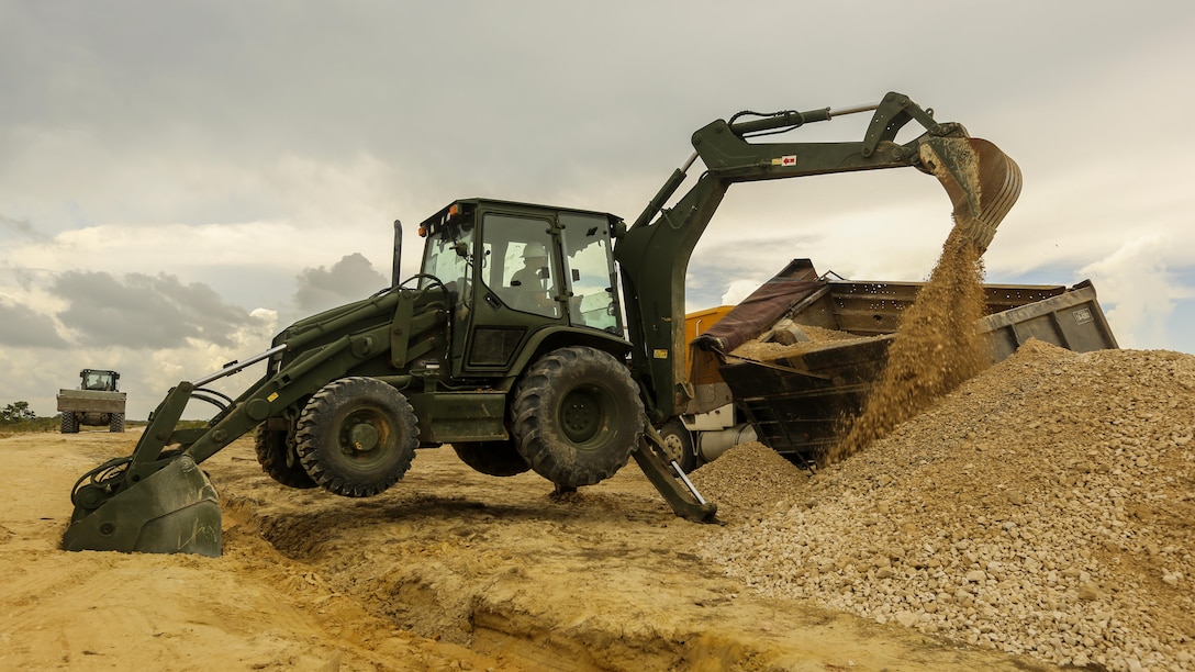 A U.S. Marine with Marine Wing Support Detachment 31, in support of Special Purpose Marine Air-Ground Task Force - Southern Command, uses a Backhoe Loader to help remove dirt from a damaged vehicle at the Hattieville Range Complex in Hattieville, Belize, Aug. 24, 2016. Over the next several months, Marines from MWSD-31 will be working on several engineer projects in Belize, which will help to increase partner nation capacity and strengthen regional defense and security cooperation.