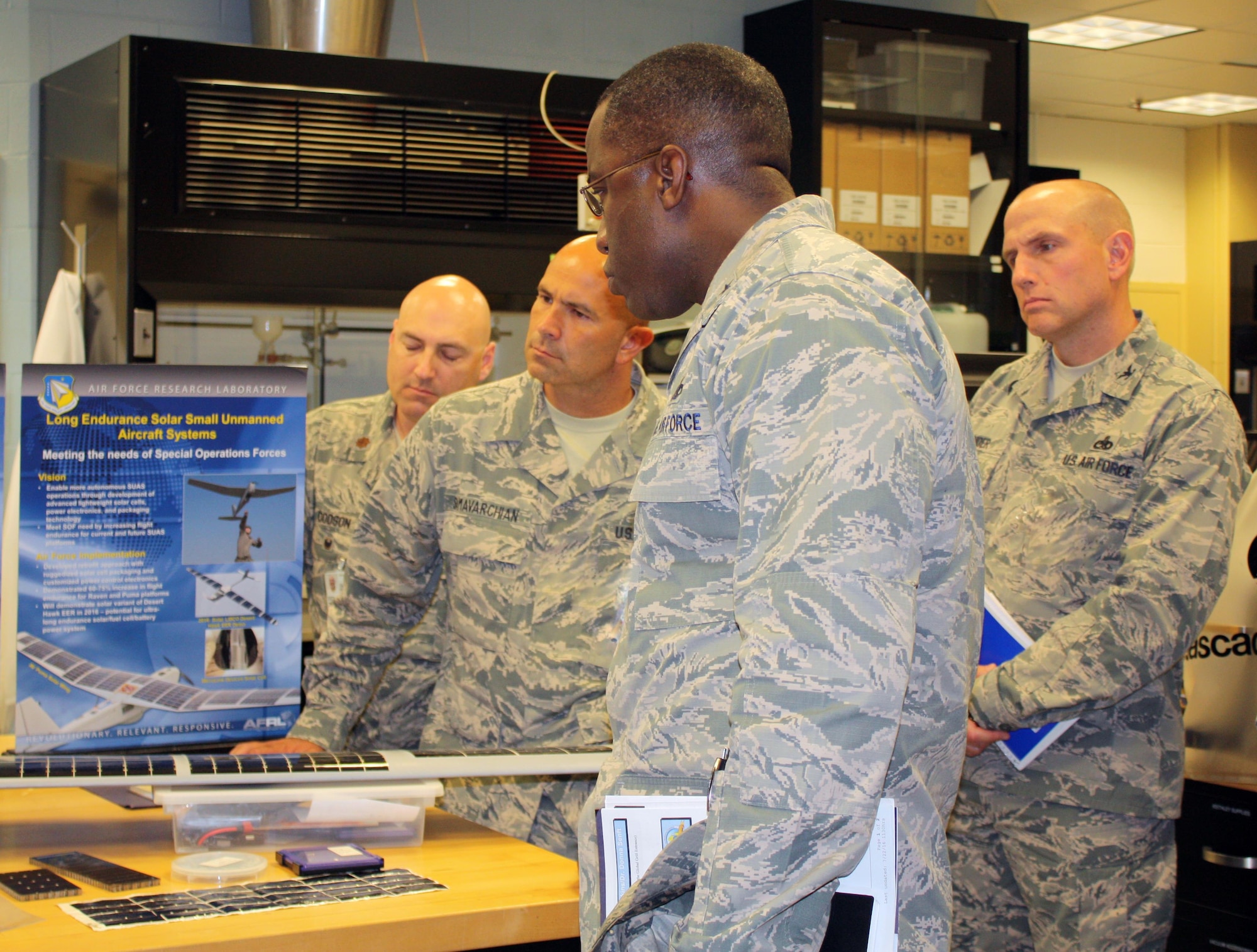 WRIGHT-PATTERSON AIR FORCE BASE, Ohio – Brig. Gen. Stacey T. Hawkins, Director, Logistcs, Engineering and Force Protection, Air Mobility Command (center) learns more about additive manufacturing capabilities for functional materials during a visit to the Materials and Manufacturing Directorate, Air Force Research Laboratory, Aug. 26. The laboratory visit was part of a larger tour of AFRL facilities to gain in-depth knowledge of current capabilities for additive manufacturing technology. The visit included a directorate overview, discussions on additive manufacturing applications and visits to multiple research laboratories, highlighting 3-D printing capabilities for metals, polymer-based materials and functional material applications. AMC is exploring the possibilities of using additive manufacturing for replacement parts for aircraft during the life-cycle maintenance process. (Air Force photo by Marisa Novobilski/released)

