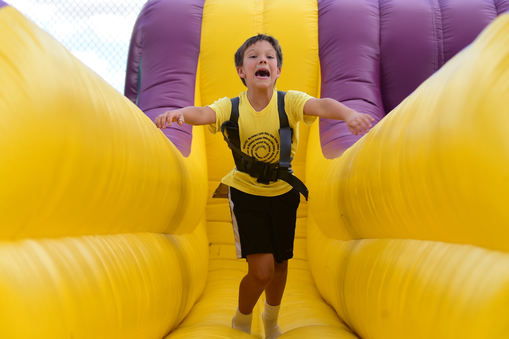 Sam, a Buckley Air Force Base child, runs as hard as he can while harnessed to bungee cord during FunFest Aug. 26, 2016, on Buckley AFB, Colo. A variety of inflatable games were erected as attractions for children of the base community to play on. (U.S. Air Force photo by Senior Airman Luke W. Nowakowski/Released)