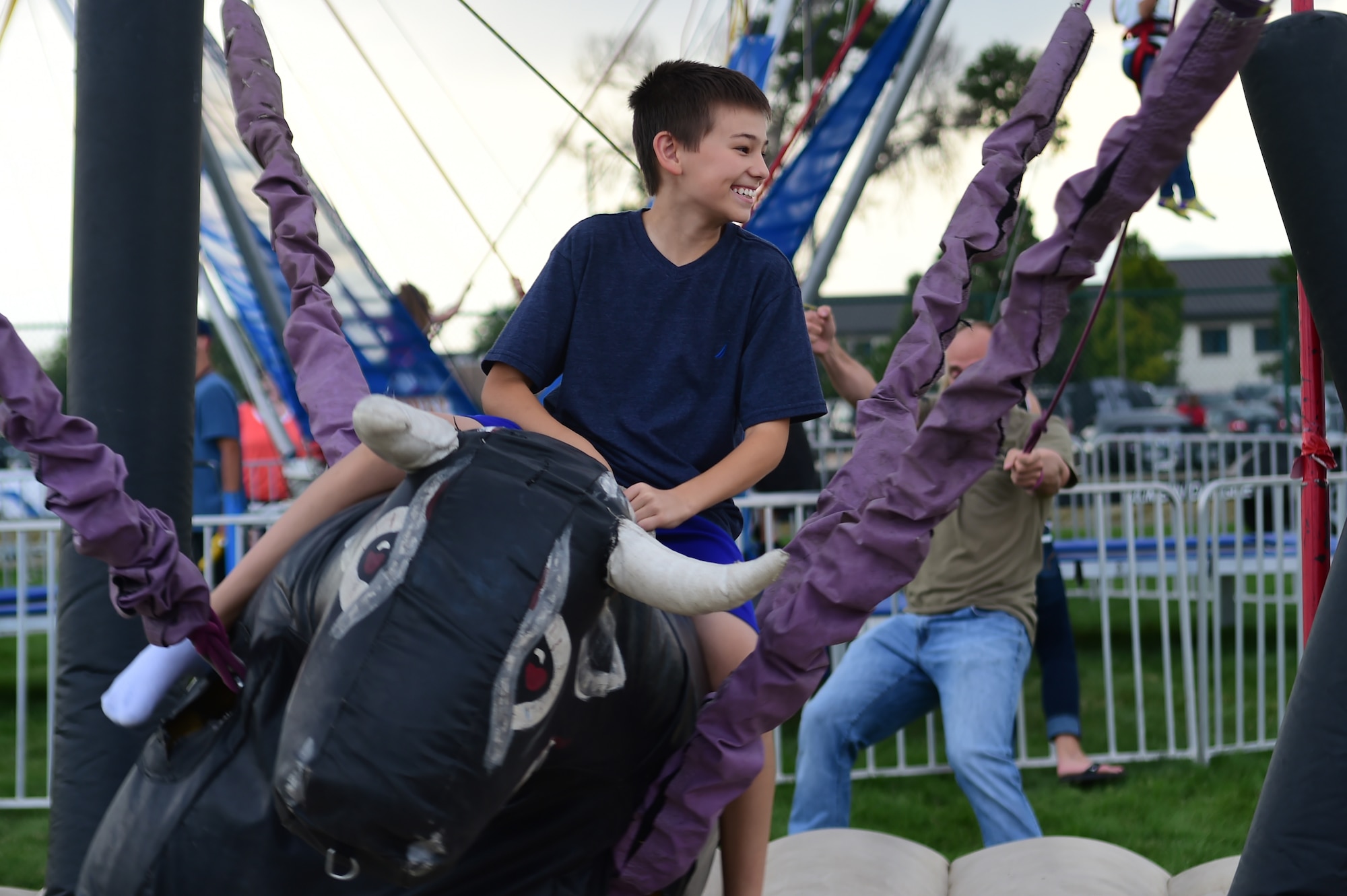 Tristan, a Buckley Air Force Base child, holds on tight while riding an inflatable bull during FunFest Aug. 26, 2016, on Buckley AFB, Colo. FunFest provided members of the Buckley community with a variety of different attractions for all ages to enjoy. (U.S. Air Force photo by Senior Airman Luke W. Nowakowski/Released)