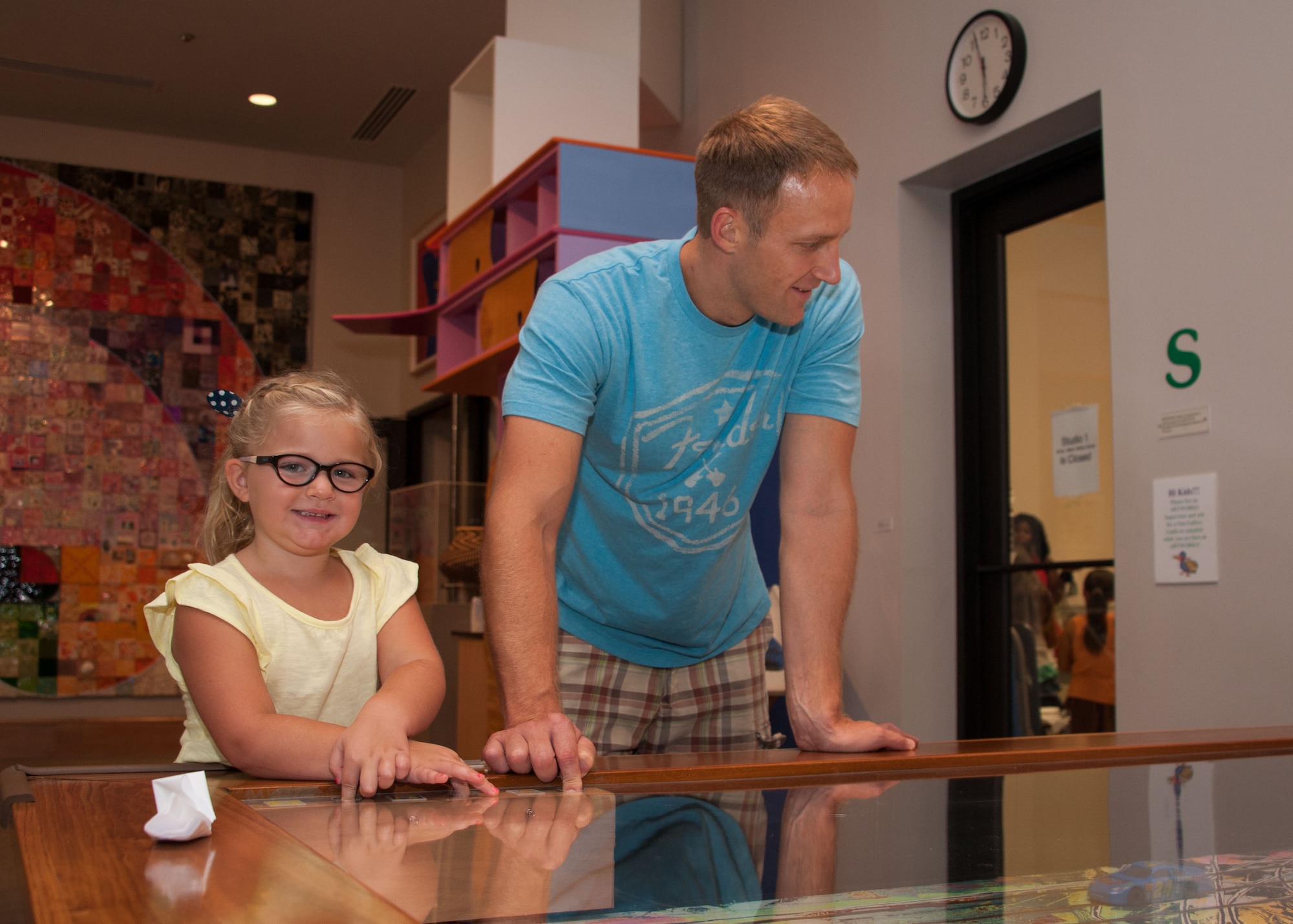 ACSC student Major Nathan Olsen and daughter Olivia look over an expressionist style-painted toy race track, at the MMFA Military Appreciation night, September 25, 2016.   (US Air Force photo by Bud Hancock)