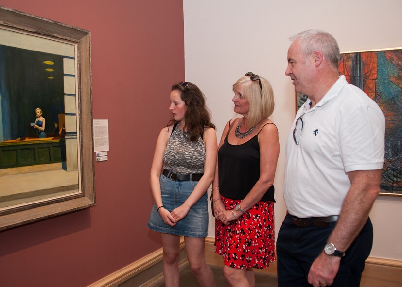 Royal Air Force Group Captain Paul Taylor, his wife Angela, and daughter Olivia view a painting at the MMFA Military Appreciation night, September 25, 2016.  Group Captain Taylor is a student at the Air War College.. (US Air Force photo by Bud Hancock)