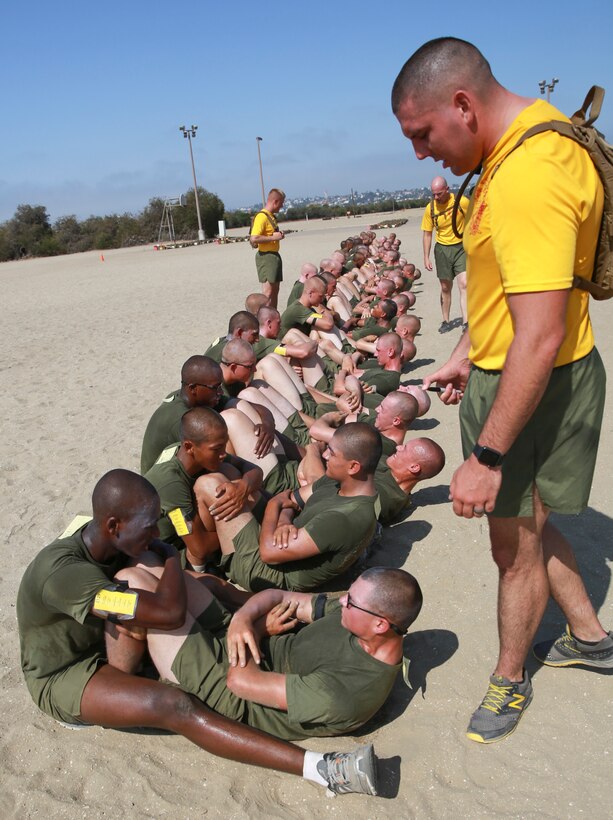 A drill instructor from Fox Company, 2nd Recruit Training Battalion, corrects a recruit’s form during an inventory physical fitness test at Marine Corps Recruit Depot San Diego, Aug. 28. Recruits must complete 100 crunches in less than two minutes to obtain a perfect score on the crunches portion of the PFT. Annually, more than 17,000 males recruited from the Western Recruiting Region are trained at MCRD San Diego. Fox Company is scheduled to graduate Sept. 23.