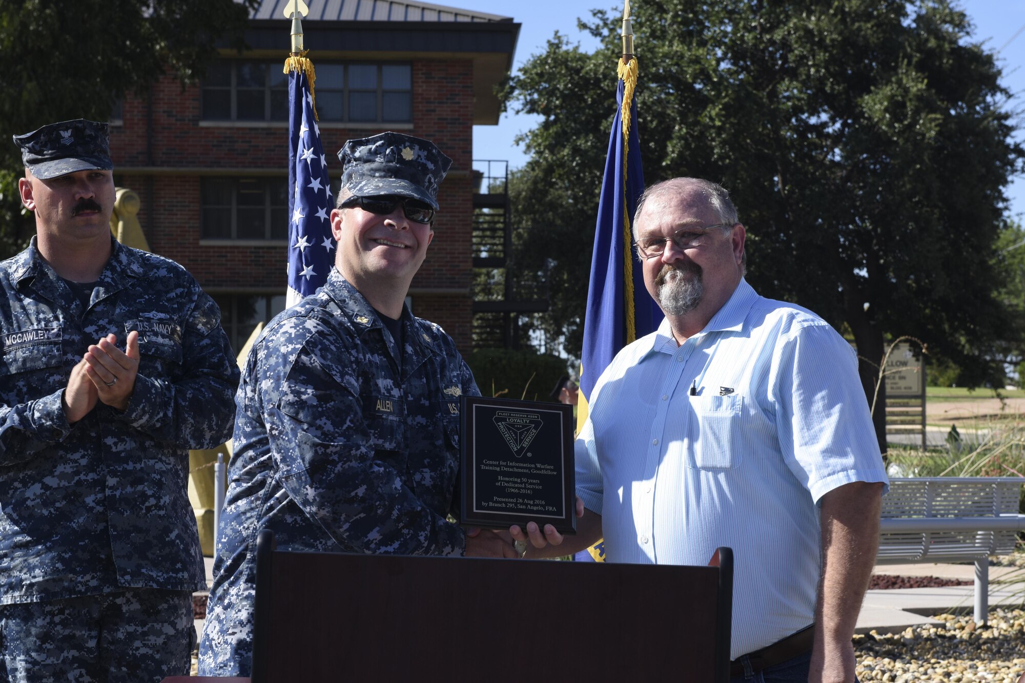 U.S. Navy Lt. Cmdr. Christopher Allen, Center for Information Dominance Detachment Officer in Charge, accepts a plaque honoring 50 years of dedicated service at the Liberty Memorial on Goodfellow Air Force Base, Texas, Aug. 26. The plaque symbolized the detachment’s 50th anniversary on Goodfellow. (U.S. Air Force photo by Airman 1st Class Chase Sousa/Released)