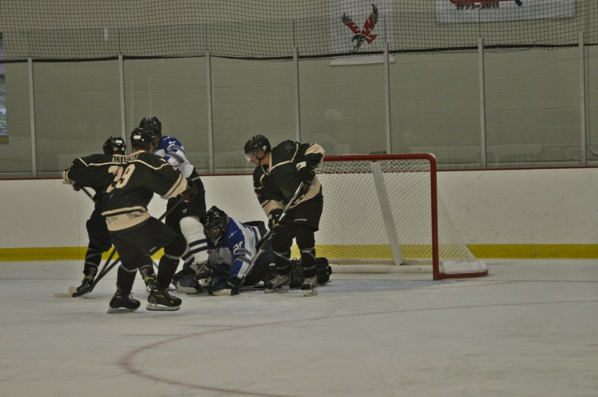 Players from Fairchild Falcons, blue, stop a puck from being hit into the goal by Joint Base Lewis-McChord players during the Veterans Hockey Game Aug. 27, 2016 at Eastern Washington University Recreational Center in Cheney, Wash. “The game was entertaining and educational for our team,” said Master Sgt. Richard Ortega, 92nd Air Refueling Wing Inspector General wing inspection team manager, and Falcons coach. “We learned some of our shortfalls and strengths.” (U.S. Air Force Photo/Airman 1st Class Taylor Shelton)