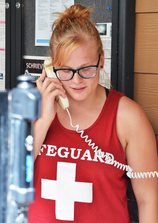 Lifeguard Jaimie Dieter calls 9-1-1 during an exercise in the Tierra Vista Communities pool at Schriever Air Force Base, Colorado, Friday, Aug. 26, 2016. The training exercise tested the response of both the lifeguards and Schriever Fire Department to a potential drowning incident at the pool. (U.S. Air Force photo/Brian Hagberg)