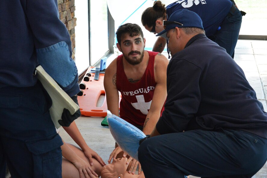 Lifeguard Matthew Johnson gives victim information to Schriever firefighters during a training exercise in the Tierra Vista Communities pool at Schriever Air Force Base, Colorado, Friday, Aug. 26. 2016. The exercise tested the responses of lifeguards and the fire department to a potential drowning incident at the pool. (U.S. Air Force photo/Brian Hagberg)