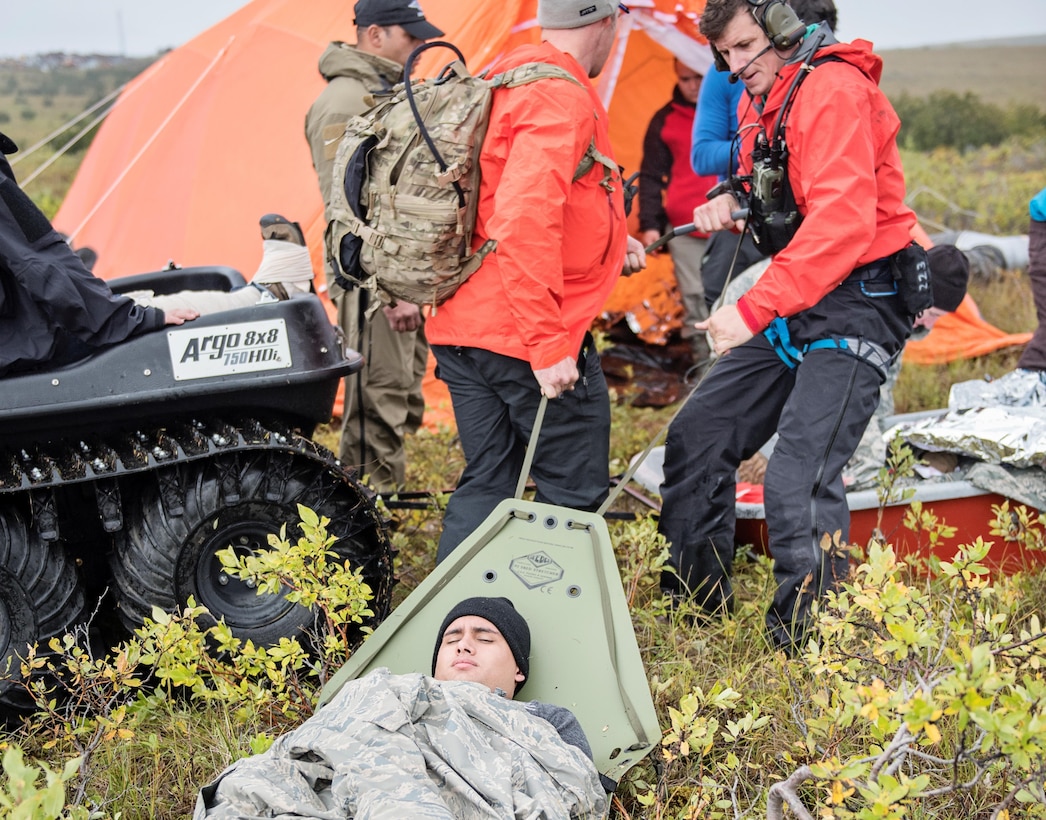Pararescuemen from the 212th Rescue Squadron, Alaska Air National Guard, move a simulated casualty to their Arctic Sustainment Package during exercise Arctic Chinook, near Kotzebue, Alaska, August 23. Arctic Chinook is a joint U.S. Coast Guard and U.S. Northern Command sponsored exercise which focuses on multinational search and rescue readiness to respond to a mass rescue operation requirement in the Arctic. (U.S. Air National Guard photo by Staff Sgt, Edward Eagerton/released)