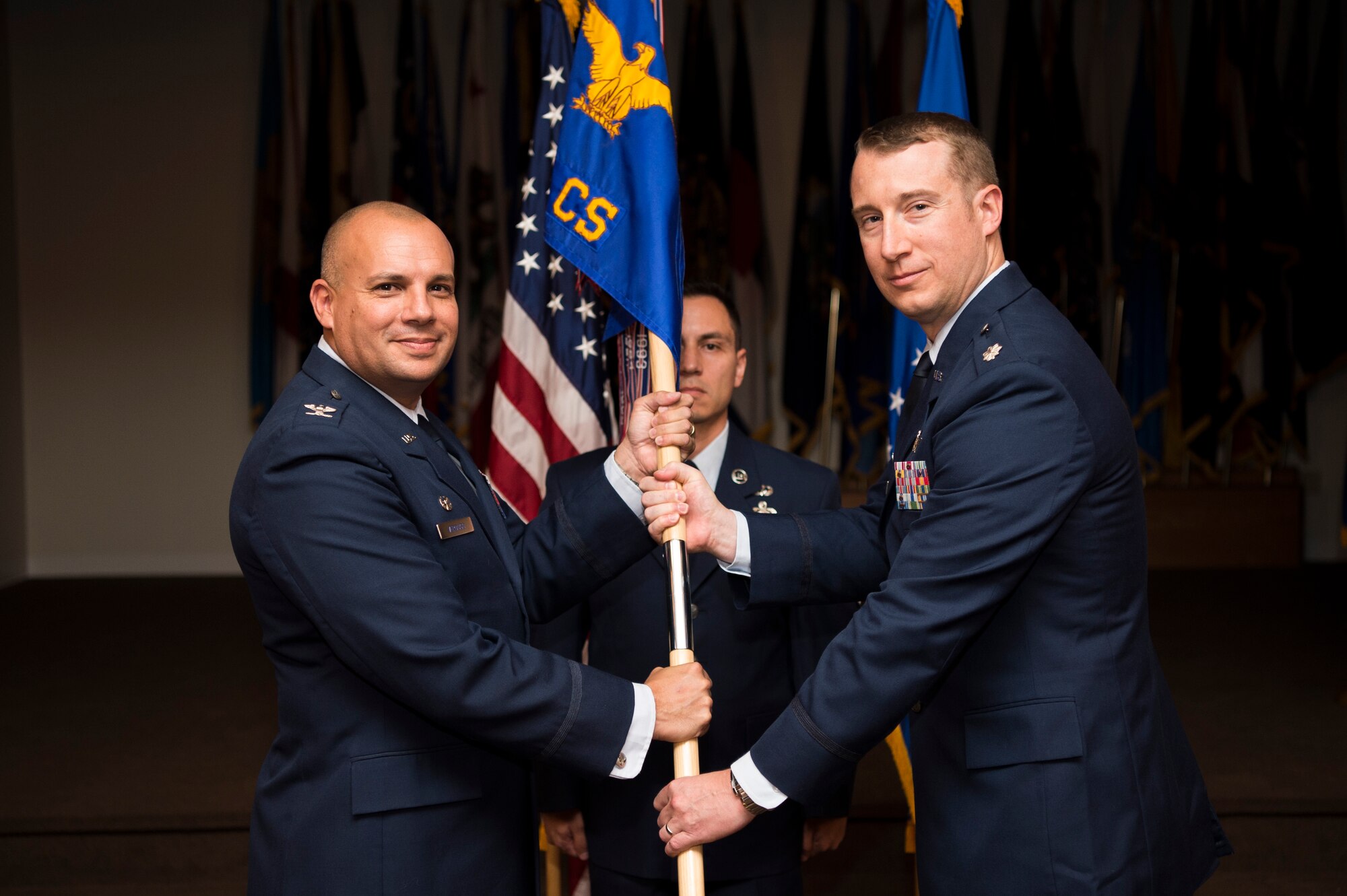 Col. Frank Verdugo, 90th Mission Support Group commander, passes the guidon to Lt. Col. Josef Chesney, 90th Communications Squadron commander, during the 90th CS assumption of command at F.E. Warren Air Force Base, Wyo., Aug. 29, 2016. An assumption-of-command ceremony is a tradition that represents a new commander assuming responsibility from the outgoing commander. (U.S. Air Force photo by Staff Sgt. Christopher Ruano)