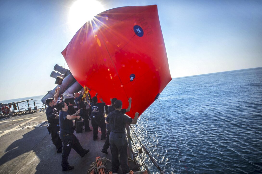 Sailors throw a "killer tomato," or inflatable target, into the water during a live-fire exercise aboard the guided-missile cruiser USS Monterey in the Arabian Gulf, Aug. 26, 2016. The Monterey is supporting maritime security operations and theater security cooperation efforts in the U.S. 5th Fleet area of operations. Navy photo by Petty Officer 2nd Class William Jenkins