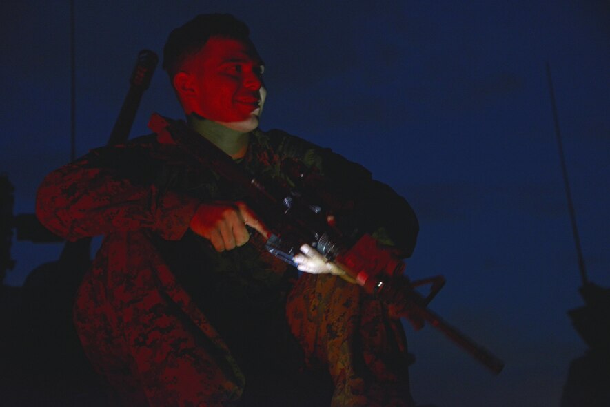 A Marine holds an M-4 rifle on top of a light-armored vehicle during a training scenario in a field near Camp Fuji, Japan, Aug. 24, 2016. Marines stationed at Camp Fuji conduct regular training exercises to ensure their mobility and mission readiness through various rough terrain. They worked with the Yokota Arts and Crafts to allow photo enthusiasts to practice their photography skills simultaneously. (U.S. Air Force photo by Senior Airman David Owsianka/Released)