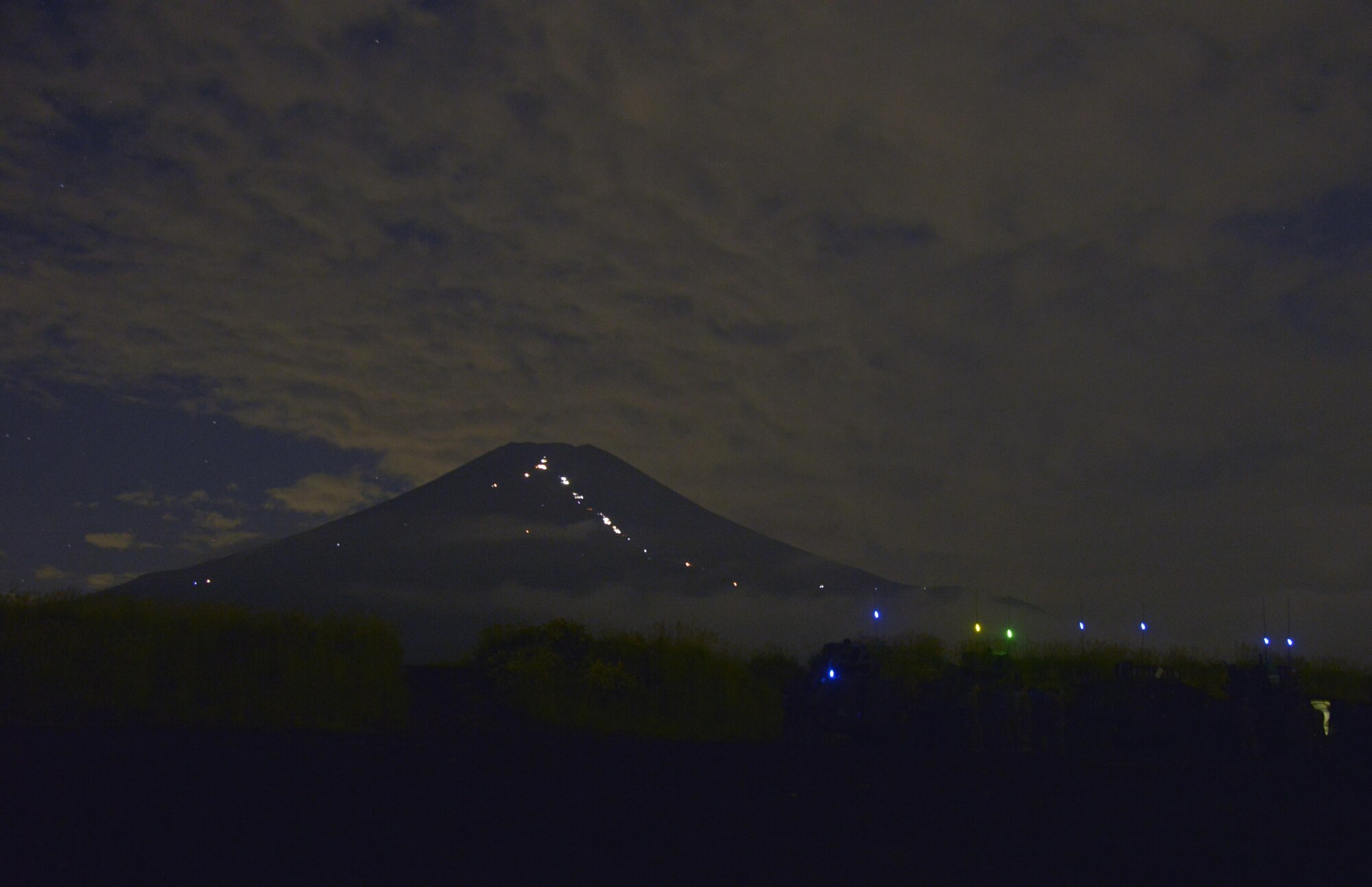 Mt. Fuji sits in the distance as Marines complete training in a field near Camp Fuji, Japan, Aug. 24, 2016. The Yokota Arts and Crafts Center held a class for photography enthusiasts to experience what it is like to take pictures in a combat situation and in a low-light environment. (U.S. Air Force photo by Senior Airman David Owsianka/Released)