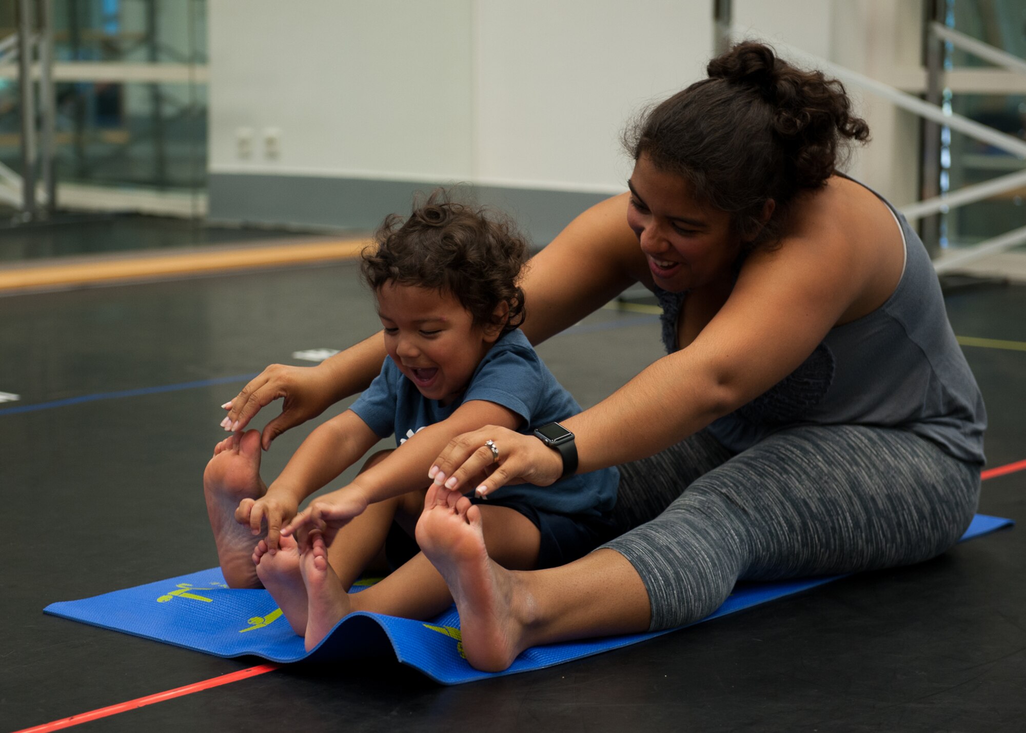 Kadyzshea Barrios and her son, Roy, reach for their toes during a Mommy and Me Yoga class Aug. 29, 2016, at Ramstein Air Base, Germany. This is the first Mommy and Me Yoga class to be offered at Ramstein. (U.S. Air Force photo/ Airman 1st Class Savannah L. Waters)