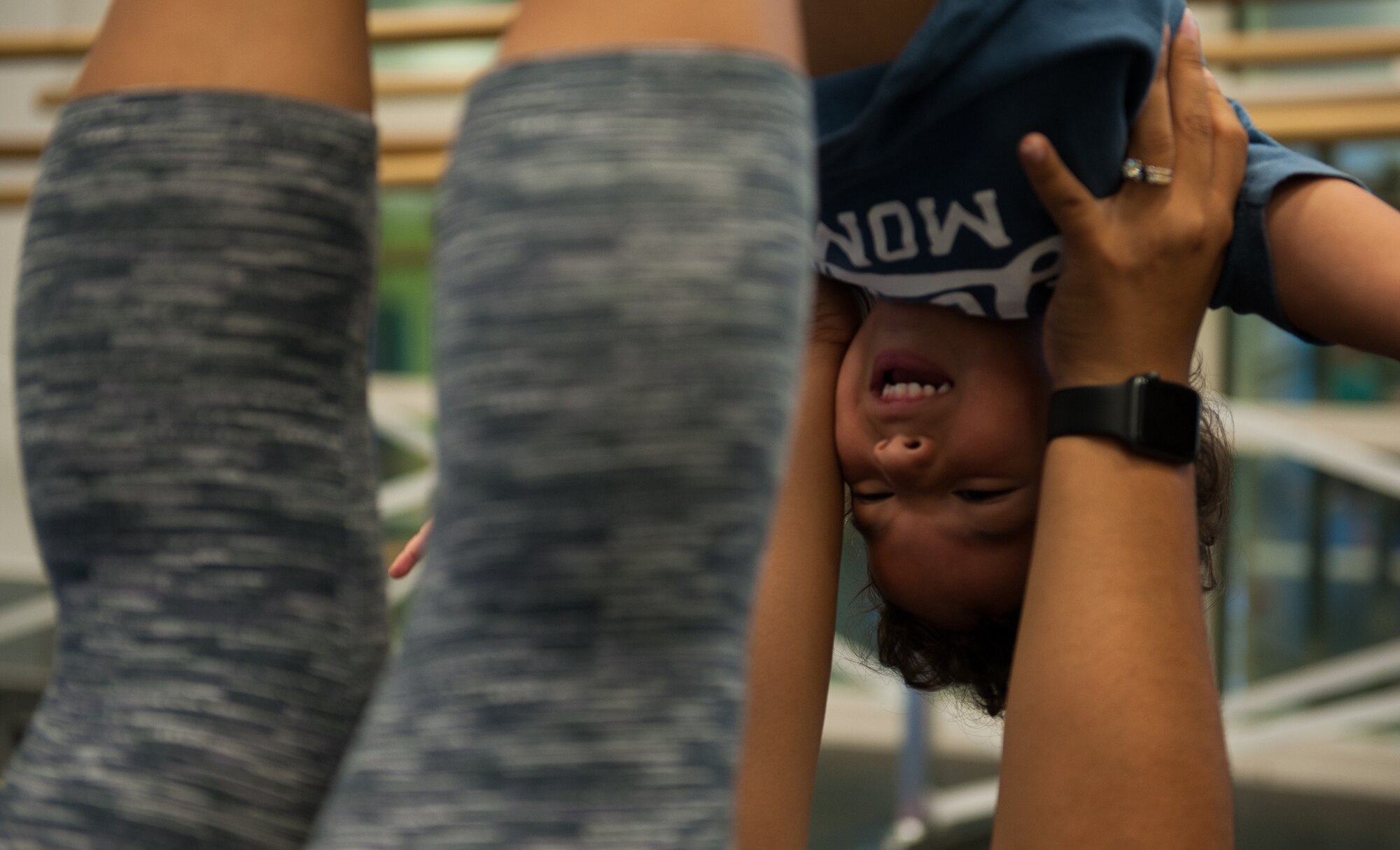 Kadyzshea Barrios lifts her son Roy in the air with her feet during the first Mommy and Me Yoga class Aug. 29, 2016, at Ramstein Air Base, Germany. Compared to a yoga course for adults, the Mommy and Me Yoga classes have more movement and hold poses for shorter amounts of time. (U.S. Air Force photo/ Airman 1st Class Savannah L. Waters)