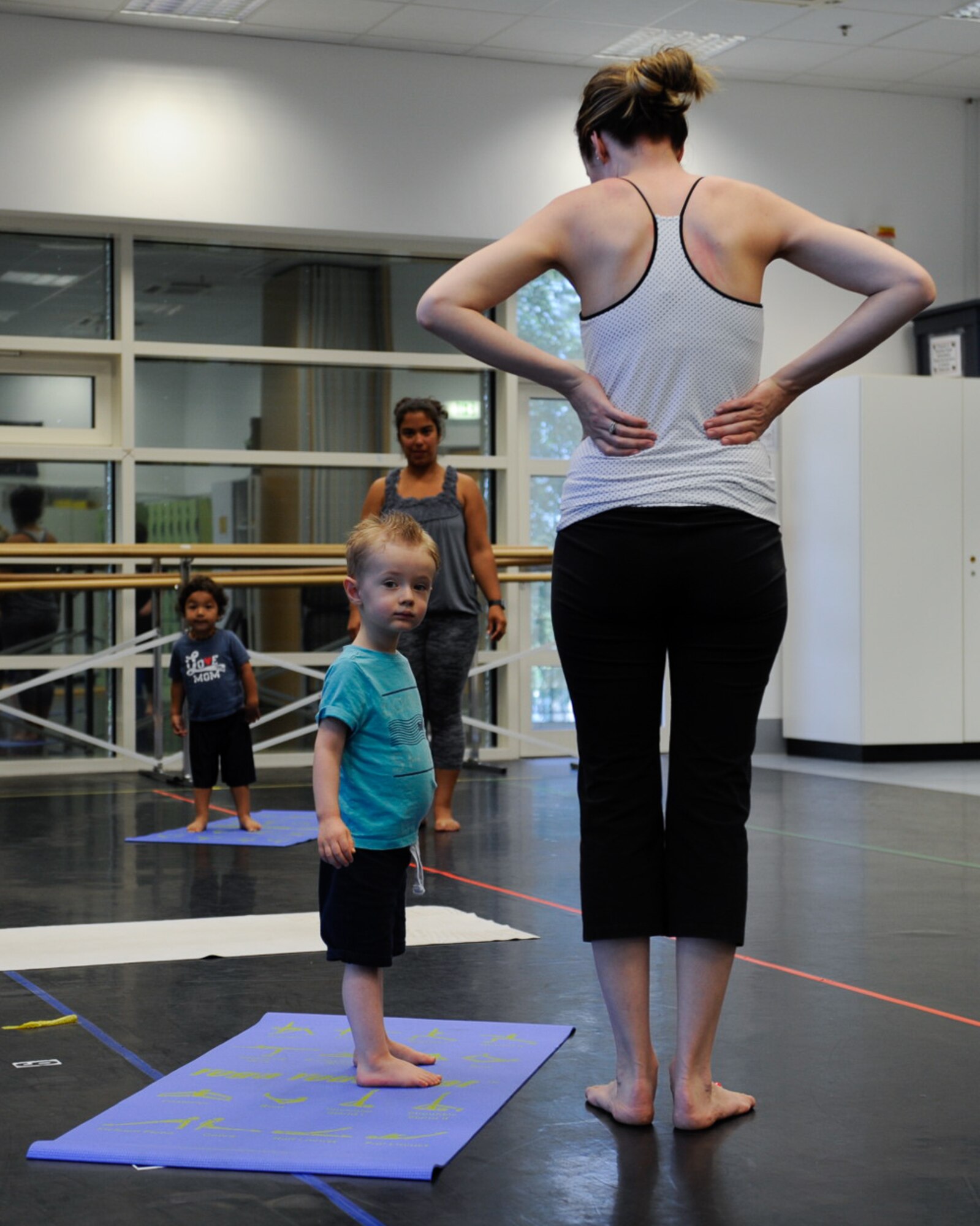 Students stand on their mats during the first Mommy and Me Yoga class Aug. 29, 2016, at Ramstein Air Base, Germany. During the class, children learn to follow directions, increase balance, muscle strength and coordination with the help of both the teacher and parent. (U.S. Air Force photo/ Airman 1st Class Savannah L. Waters)

