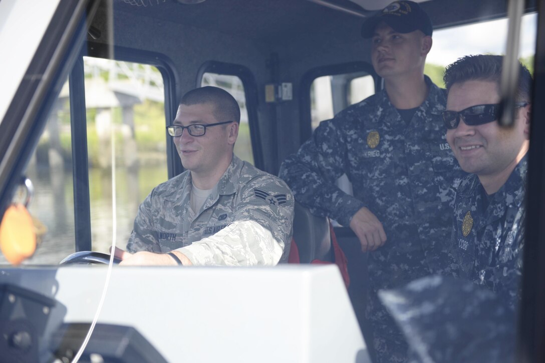 Air Force Senior Airman Austin Walworth, left, trains with Navy Petty Officer 1st Class Jeremy Krieg and Navy Petty Officer 1st Class Brian Cobb on a harbor patrol boat with the 628th Security Forces Squadron at Joint Base Charleston, S.C., Aug. 15, 2016. Walworth is believed to be the first airman to earn the Navy Small Craft Insignia, or Coxswain Pin. Navy Photo by Petty Officer 2nd Class John Haynes