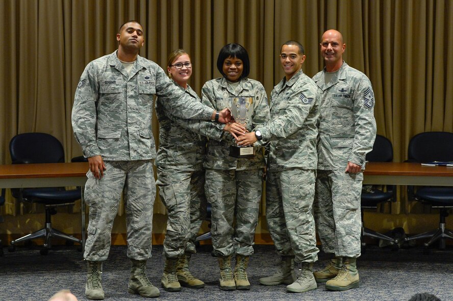 Chief Master Sgt. John Bentivegna (right), 50th Space Wing command chief, presents the Schriever Debate trophy to the 5/6 Council debate team following the first Schriever Debate at Schriever Air Force Base, Colorado, Thursday, Aug. 25, 2016. The 5/6 Council defeated the CGO Council in the first iteration of the new event. (U.S. Air Force photo/Christopher DeWitt)