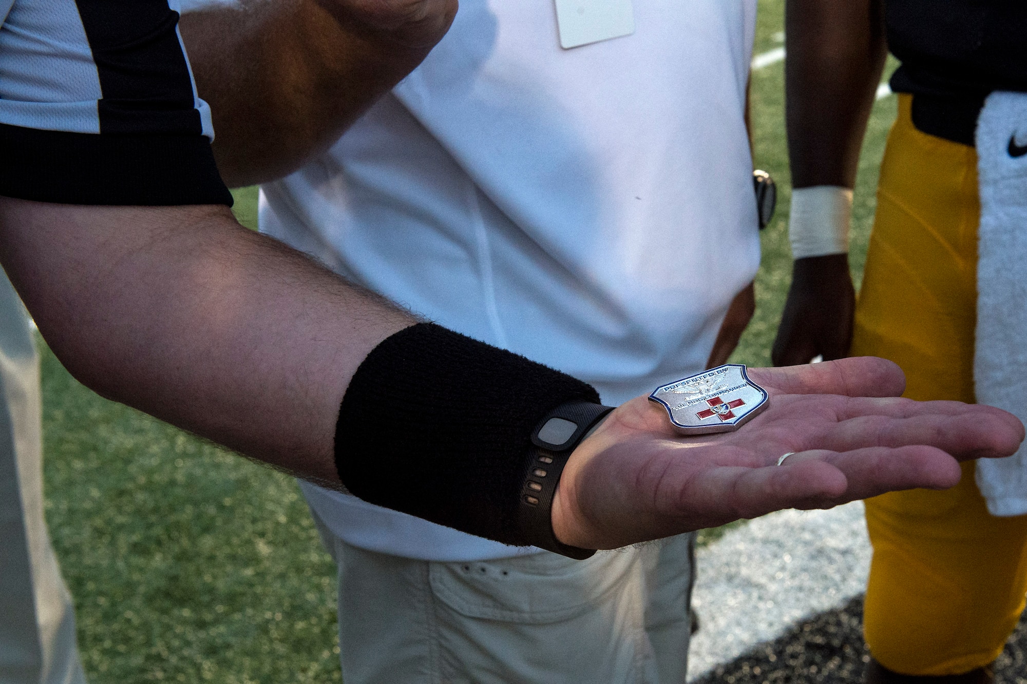 A referee holds the coin of U.S. Air Force Col. Jay Vietas, 23d Medical Group commander, after performing the official Military Appreciation Night coin toss, Aug. 26, 2016, in Valdosta, Ga. As part of the game, Vietas assisted with the coin toss by providing a personal coin. (U.S. Air Force photo by Airman 1st Class Janiqua P. Robinson)