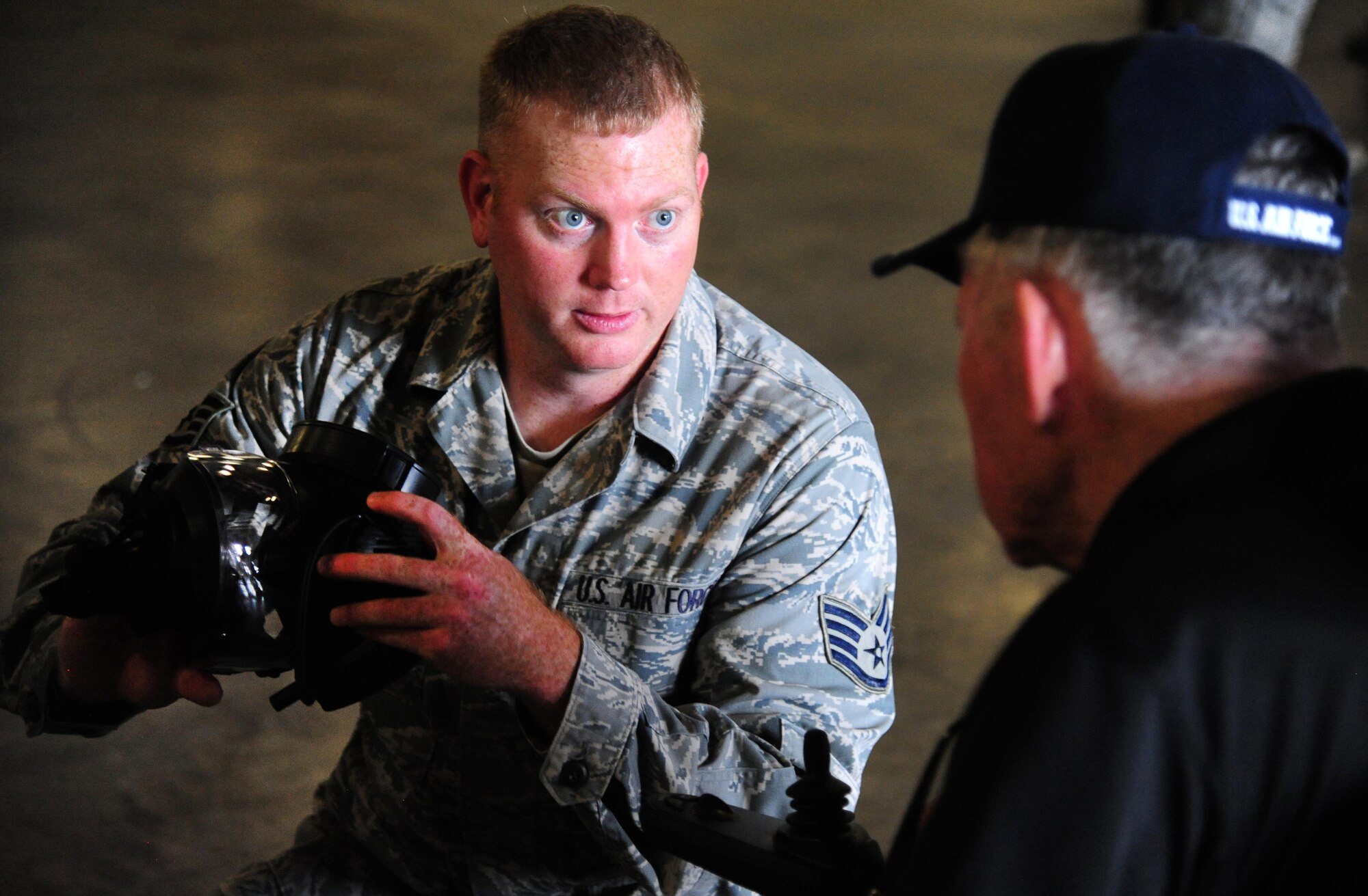 U.S. Air Force Staff Sgt. Brian Rowlette, an individual protective equipment supervisor from the 509th Logistics Readiness Squadron, explains the uses and specifications of an M50 gas mask to a veteran at Whiteman Air Force Base, Mo., Aug 26, 2016. Veterans from the Missouri Veterans' Home visited Whiteman and learned about various squadrons on base and each unit’s mission. (U.S. Air Force photo by Senior Airman Joel Pfiester)