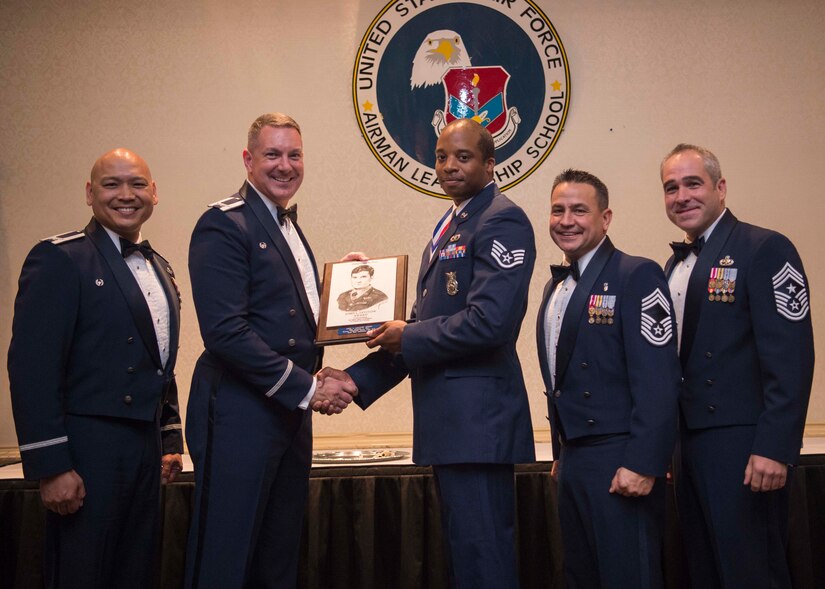 Staff Sgt. Christian Burt, 628th Civil Engineering Squadron fire protection journeyman (center), receives the John L. Levitow award from Col. Robert Lyman, 628th Air Base Wing commander (left), with Col. Jimmy Canlas, 437th Airlift Wing commander (far left), Chief Master Sgt. Chad Ballance, 628th ABW acting command chief (right) and Chief Master Sgt. Kristopher Berg, 437 AW command chief, during an Airman Leadership School graduation ceremony at the Charleston Club on Joint Base Charleston – Air Base, S.C., Aug. 25, 2016. The John L. Levitow Award is awarded to a single graduate for every Enlisted Professional Military Education course for demonstrating excellence both as a leader and scholar. (U.S. Air Force photo/Airman 1st Class Thomas T. Charlton)