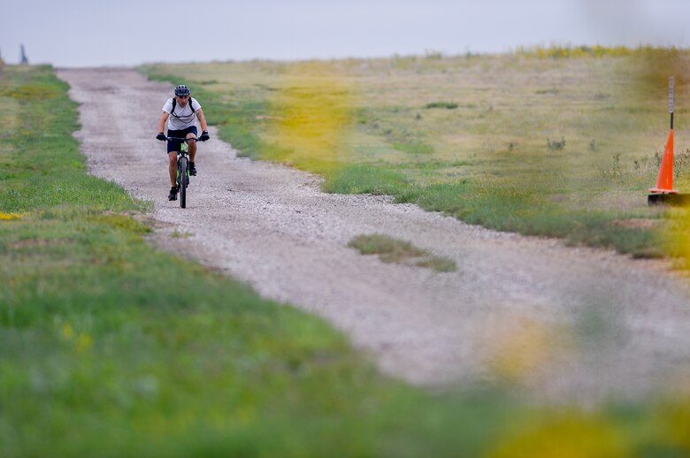 Jacob Lacefield, 50th Space Wing, rides down the bike trail during the 12th annual Schriever Air Force Base Triathlon at Schriever Air Force Base, Colorado, Friday, Aug. 26, 2016. Competitors in the event swam 400 meters in the Tierra Vista Community Center pool before heading out to bike 12 miles and run 3.1 miles on the trails around the base. (U.S. Air Force photo/Christopher DeWitt)