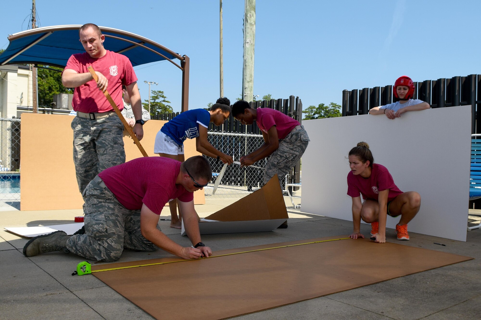 Airmen from the 4th Communications Squadron start to assemble their cardboard boat for the Build-a-Boat competition, Aug. 26, 2016, at Seymour Johnson Air Force Base, North Carolina. Teams of eight were tasked with building a boat using only cardboard and duct tape. (U.S. Air Force photo by Airman Shawna L. Keyes)  