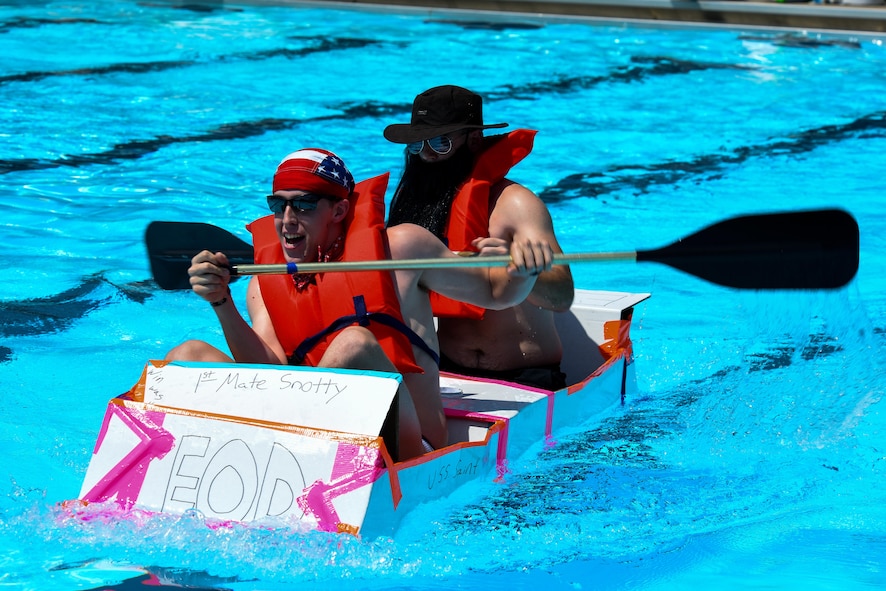 Senior Airmen Zachary Logan (left), and Senior Airman Nathanael Banden 4th Civil Engineer Squadron explosive ordnance disposal technicians, paddle in their make-shift cardboard boat, Aug. 26, 2016, at Seymour Johnson Air Force Base, North Carolina. Nine teams entered the Build-a-Boat competition but only six made it across the pool successfully without sinking. (U.S. Air Force photo by Airman Shawna L. Keyes)