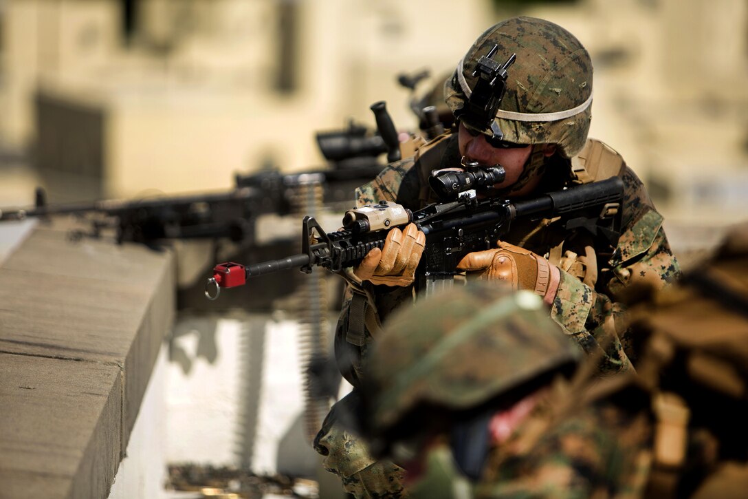 Marines secure the area around a building from the rooftop during a vertical assault training raid at Camp Lejeune, N.C., Aug. 23, 2016. Marine Corps photo by Lance Cpl. Melanye E. Martinez