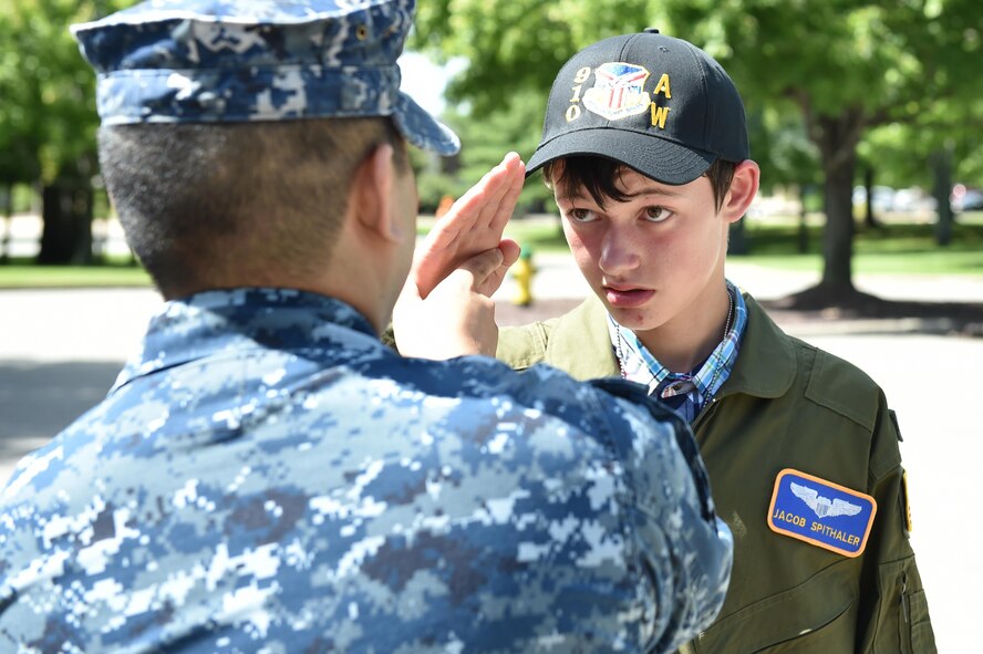 U.S. Navy Lt. Benjamin Sacramento, commander of Navy Operations Support Center Youngstown (NOSC), shows 14-year-old Jacob Spithaler how to render a Navy salute here, Aug. 24, 2016. Spithaler was the 64th honoree of the 910th Airlift Wing’s Pilot for a Day Program in which children with chronic or life-threatening illnesses are welcomed to the station, commissioned as honorary second lieutenants and treated to a day of fun military themed activities. Members of Sacramento’s staff welcomed Spithaler to the NOSC with a piping aboard ceremony. (U.S. Air Force photo/Eric White)