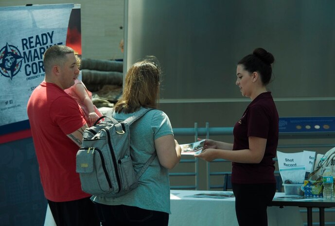 A Ready Marine Corps Team Member (right) discuss making an emergency plan with a family. 