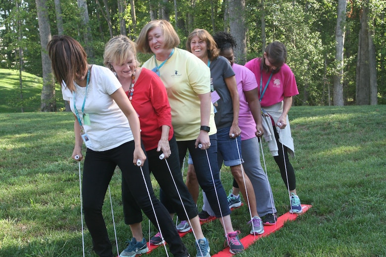 Teachers at Kyle Wilson Elementary School in Prince William County use skis to role-play moving as a family to a new duty station, stopping to visit family along the way. The exercise was part of the "PCS Challenge," in which teachers were given a chance to experience what their military students experience moving with their families. The training was held Aug. 24 and led by school liaisons from Marine Corps Base Quantico and Fort Belvoir.