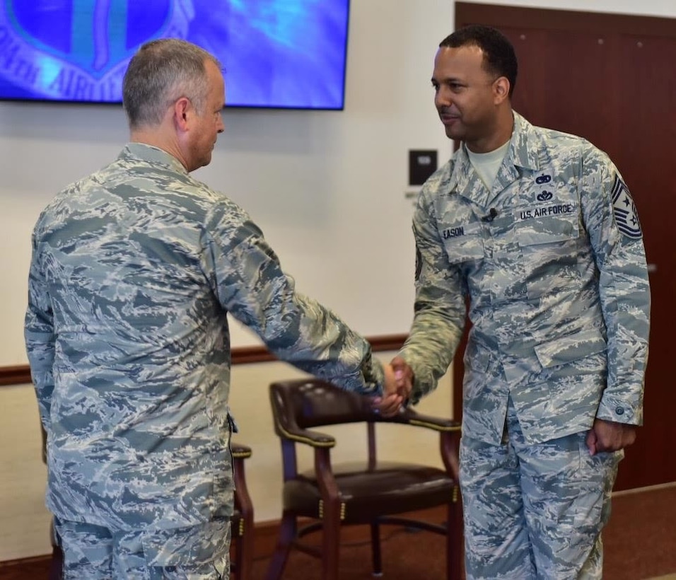 Col. Brian Bowman, commander, 914th Airlift Wing congratulates Chief Master Sgt. Kenneth Eason, command chief, 914 AW during a ceremony at Niagara Falls Air Reserve Station on Aug. 6, 2015. Eason assumes the responsibility of the highest enlisted position in the Wing. (U.S. Air Force photo by Staff Sgt. Richard Mekkri)