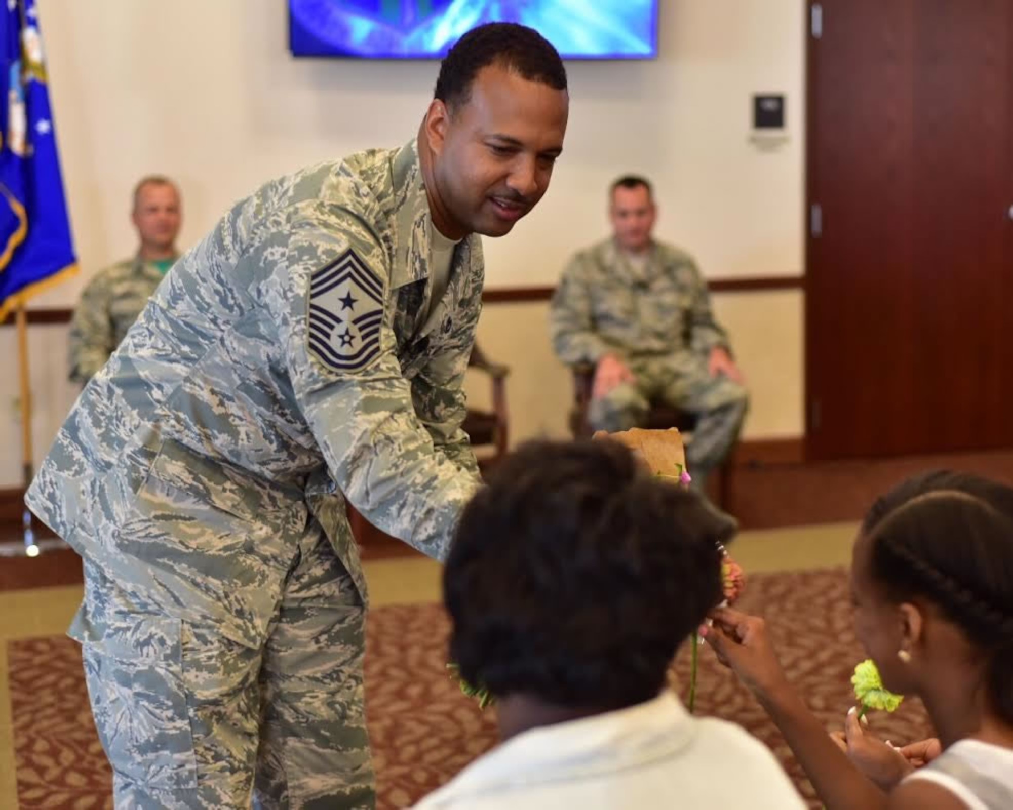 Chief Master Sgt. Kenneth Eason, command chief, 914th Airlift Wing, presents gifts to members of his family during a ceremony at Niagara Falls Air Reserve Station on Aug. 6, 2015. Eason assumes the responsibility of the highest enlisted position in the Wing. (U.S. Air Force photo by Staff Sgt. Richard Mekkri)