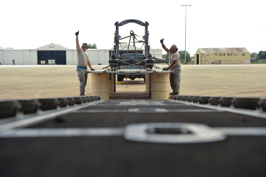 Airmen from the 305th Aerial Port Squadron at Joint Base McGuire-Dix-Lakehurst, New Jersey, gives a thumbs up to communicate to 41st Airlift Squadron loadmasters from Little Rock Air Force Base, Ark., that the combat offload method B is complete Aug. 26, 2016, at a landing zone in Alexandria, Louisiana. This method is practiced and perfected so Airmen are equipped with the necessary skills needed for deployment operations. (U.S. Air Force photo by Staff Sgt. Regina Edwards)
