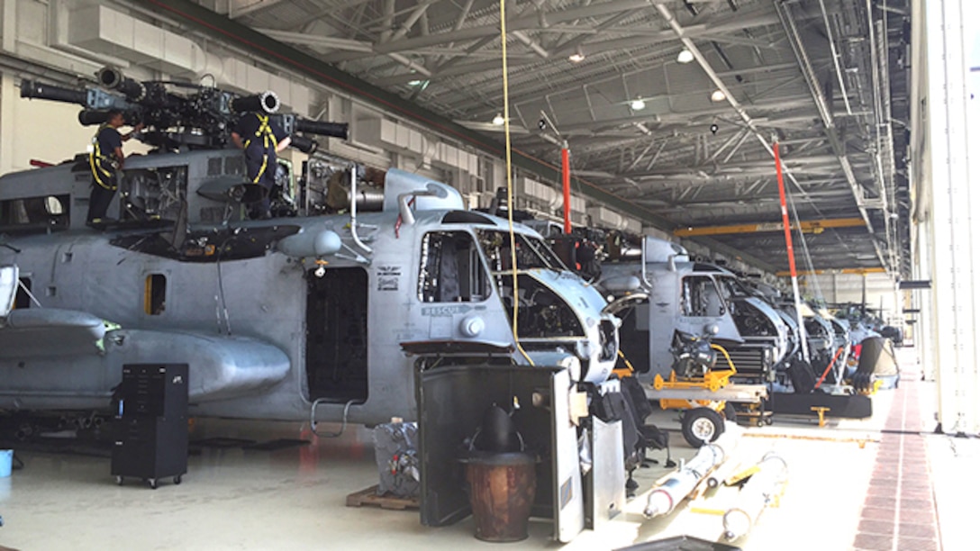 Aircraft maintenance professionals at the Marine Corps Air Station New River RESET support site in Jacksonville, N.C. shown inspecting the main rotor head on an aging MH-53 heavy-lift helicopter. Currently 12 MH-53's require replacement of one sleeve nut on the rotor head and seven on the sleeves and spindles which are the main components for the helicopter's rotary blades. Defense Logistics Agency Aviation Customer Operations Directorate’s weapon systems program office in Richmond, Virginia, is part of the management team that helps keep the MH-53 helicopter fleet mission ready.