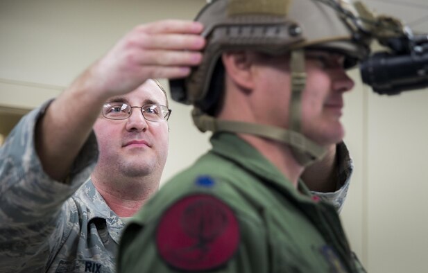 Staff Sgt. Joshua Rix, 919th Special Operations Support Squadron, checks the fit of a night-vision-goggle-mounted helmet on an aircrew member at Duke Field, Fla.  The Airmen in the Aircrew Flight Equipment section of 919th SOSS ensure all flight gear and training is current and up to date for the wing’s flying personnel.  (U.S. Air Force photo/Tech. Sgt. Sam King)  