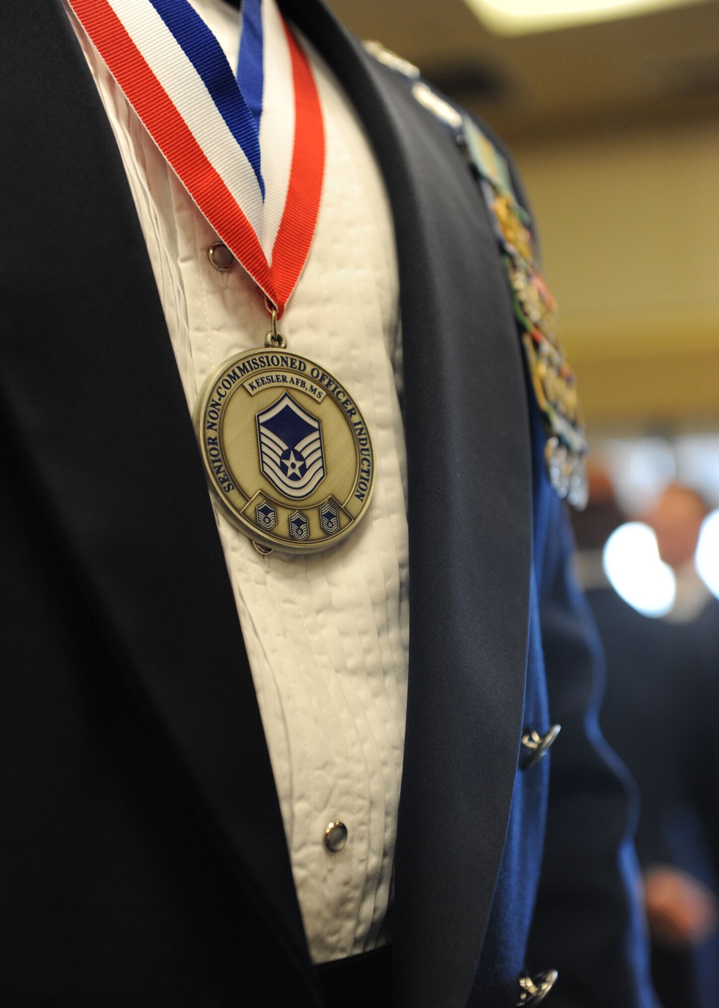 A newly-inducted senior NCO wears his medallion during the Senior Noncommissioned Officer Induction Ceremony at the Bay Breeze Event Center Aug. 18, 2016, on Keesler Air Force Base, Miss. Thirty-seven enlisted members were recognized throughout the event. (U.S. Air Force photo by Kemberly Groue/Released)