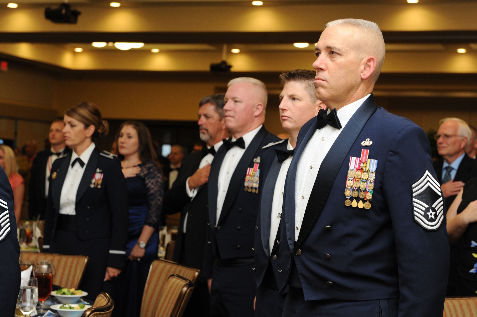 Chief Master Sgt. Robert Winters, 81st Training Group superintendent, stands at attention during the playing of the national anthem at the Senior Noncommissioned Officer Induction Ceremony at the Bay Breeze Event Center Aug. 18, 2016, on Keesler Air Force Base, Miss. Thirty-seven enlisted members were recognized and received a commemorative medallion at the event.  (U.S. Air Force photo by Kemberly Groue/Released)