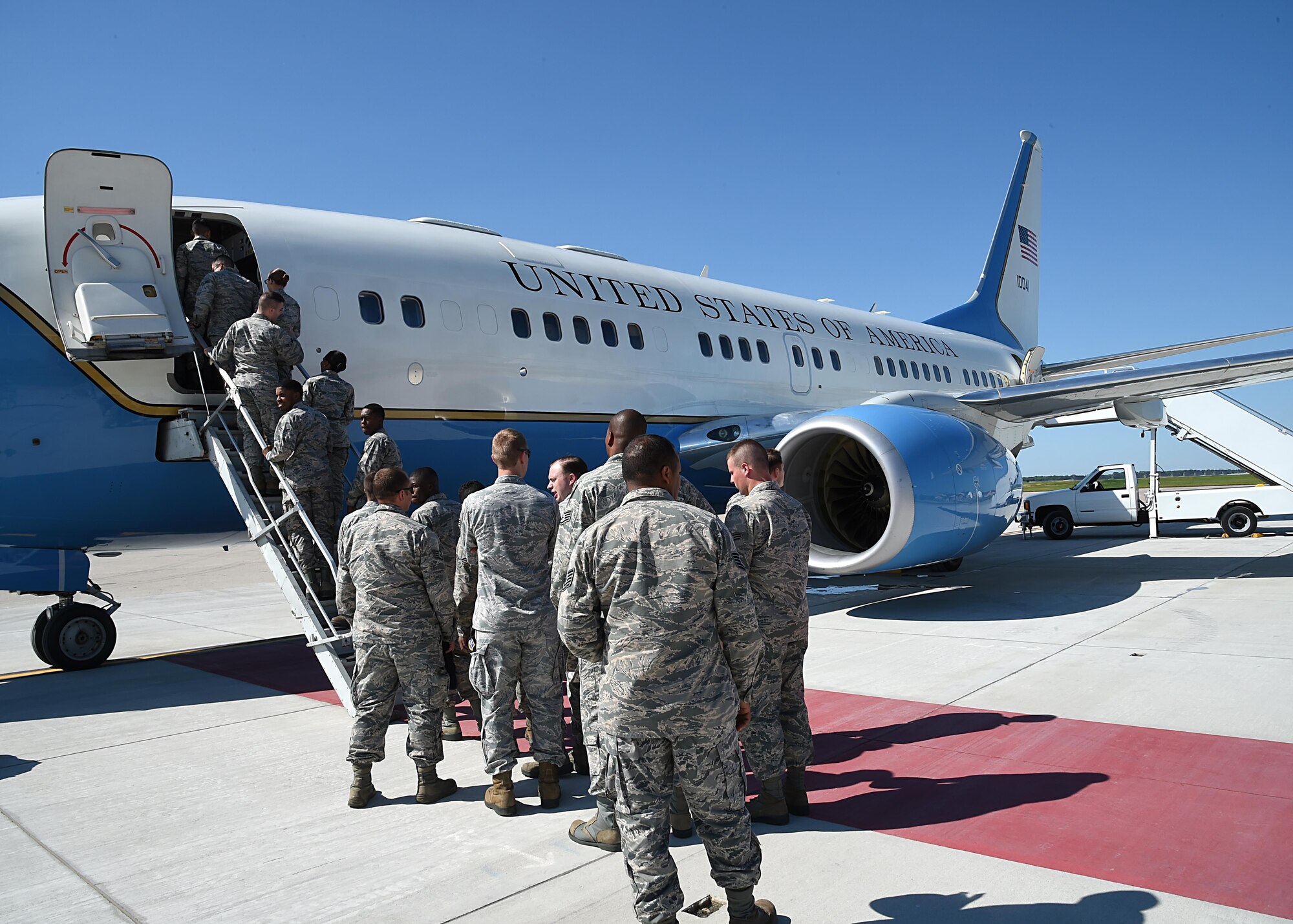 Airmen with the 319th Air Base Wing file onto a C-40B aircraft August 29, 2016, on Grand Forks Air Force Base, N.D. Airmen with the 89th Airlift Wing, Joint Base Andrews, Md., visited Grand Forks AFB to recruit Airmen for the flight attendant career field. (U.S. Air Force photo by Senior Airman Ryan Sparks/Released)