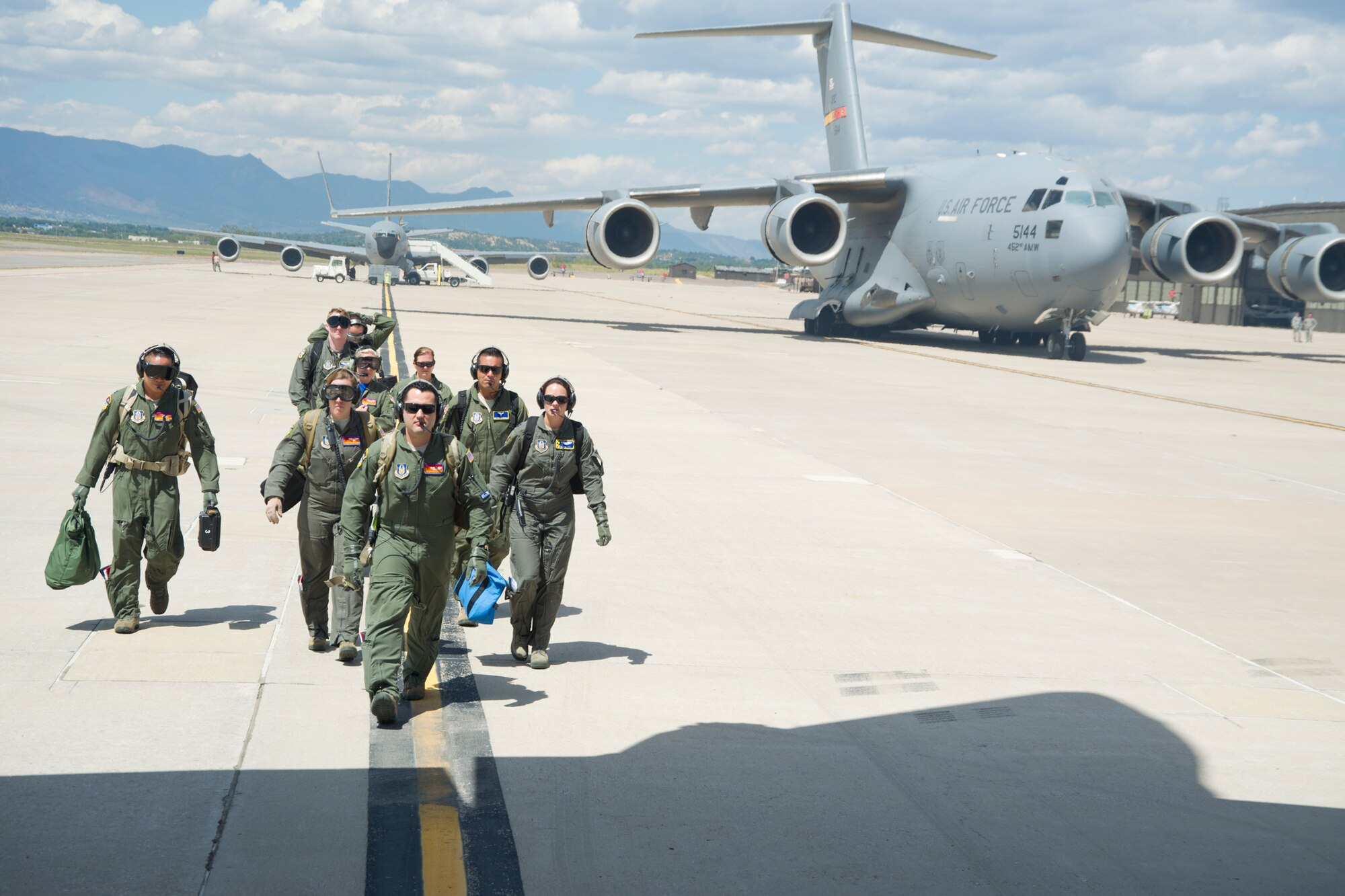 A multi-unit team of aeromedical evacuation squadron members make their way to a C-130H3 Hercules on the Peterson Air Force Base, Colorado, flight line Saturday, Aug. 27, 2016, to conduct in-flight training. More than a dozen 459th AES flight nurses, technicians and administrators flew to Peterson to conduct joint unit training with other AE squadrons on board the KC-135R Stratotanker, C-17 Globemaster III and C-130H3 Hercules. (U.S. Air Force photo/Staff Sgt. Kat Justen)