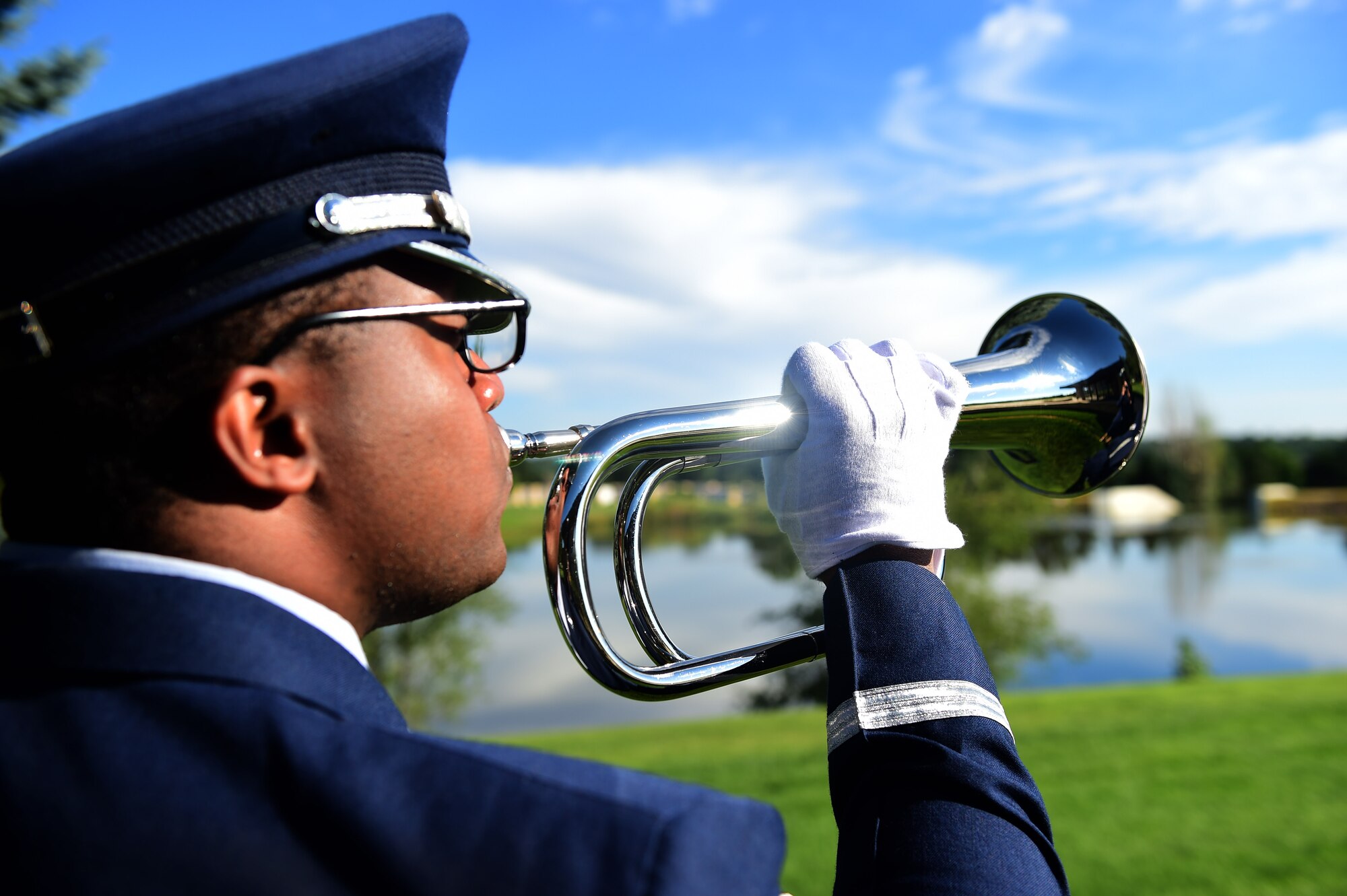 Senior Airman James Cunningham, U.S. Air Force Mile High Honor Guard member, plays taps on a bugle during a funeral August 30, 2016, at Fort Logan National Cemetery, Colo. Taps received its name in 1874, but was made the official Army Bugle call after the Civil War. (U.S. Air Force photo by Airman 1st Class Gabrielle Spradling/Released)
